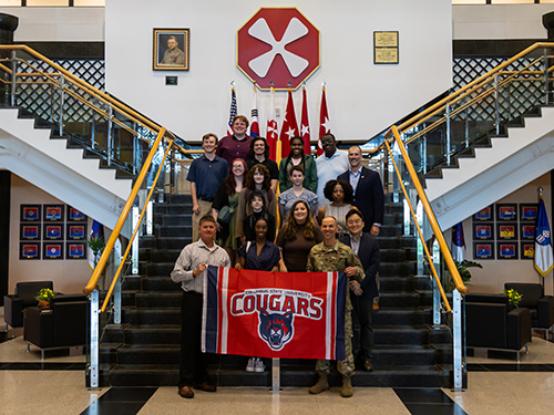 several people standing on a staircase with a CSU banner