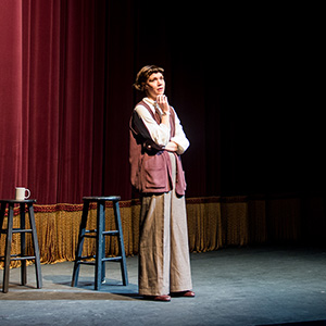 a woman standing on a stage in a thinking pose