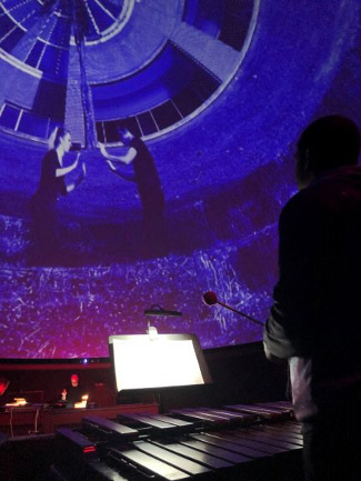 Student playing an instrument during a movie performance