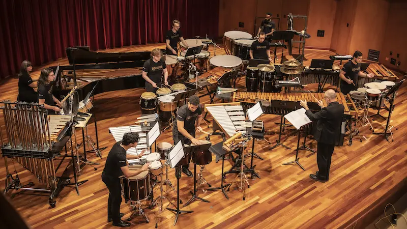 Students playing percussion instruments on stage