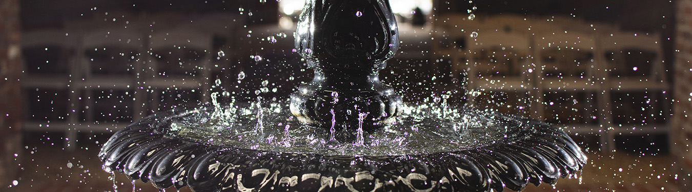 A close-up of a fountain with water falling on it