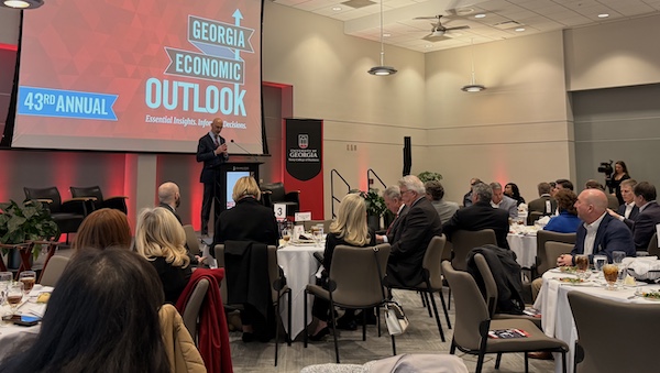 A male at a podium praying