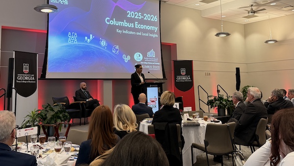 Dr. Tesa Leonce at a podium presenting