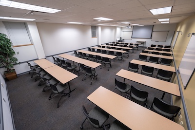 Classroom from rear, two-person desks and a whiteboard