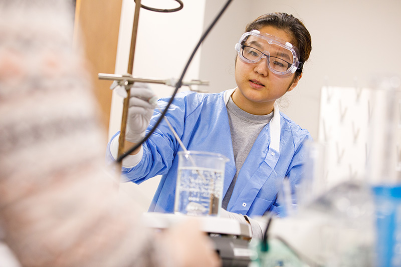 a female student dressed in safety gear in a lab
