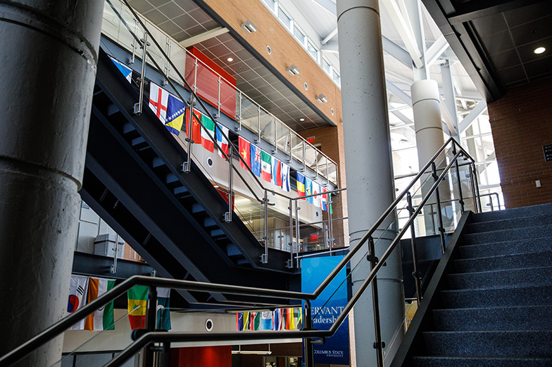 several flags hanging from a building's railings
